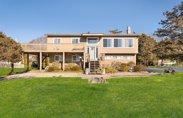 rear view of property featuring a wooden deck and a yard