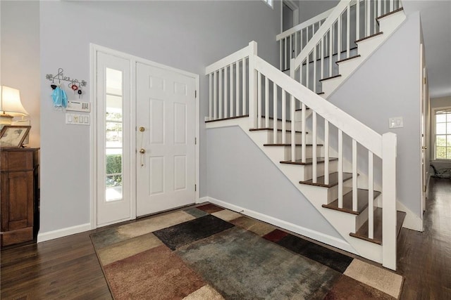 foyer featuring a towering ceiling and dark hardwood / wood-style flooring