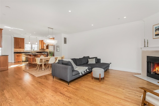 living room with crown molding and light wood-type flooring