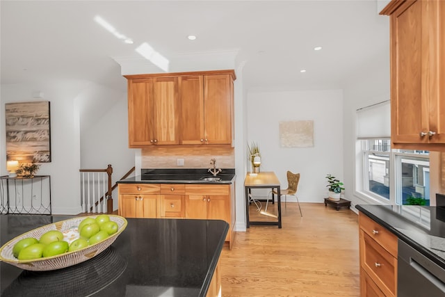 kitchen featuring sink, crown molding, light hardwood / wood-style flooring, dishwasher, and backsplash