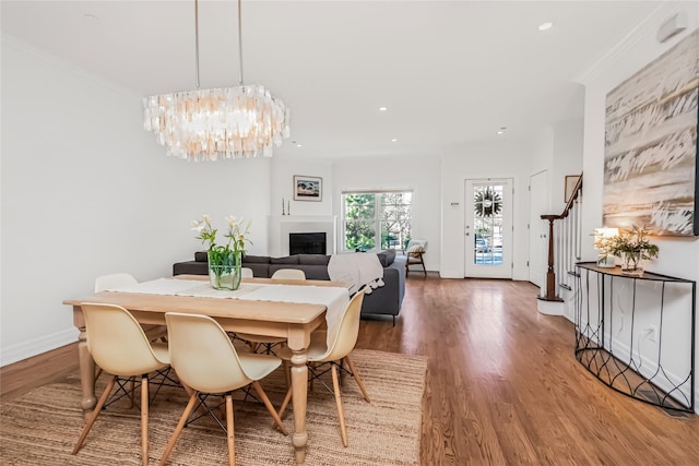 dining room with ornamental molding, wood-type flooring, and a notable chandelier