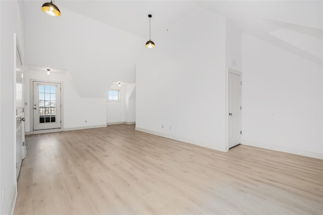 unfurnished living room featuring high vaulted ceiling and light hardwood / wood-style flooring