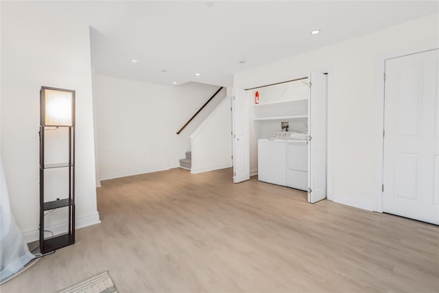 unfurnished living room with independent washer and dryer and light hardwood / wood-style flooring