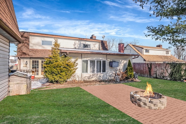 rear view of house with a patio area, a lawn, and an outdoor fire pit