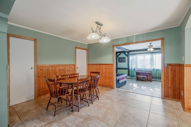 tiled dining room with ornamental molding, a textured ceiling, and a notable chandelier