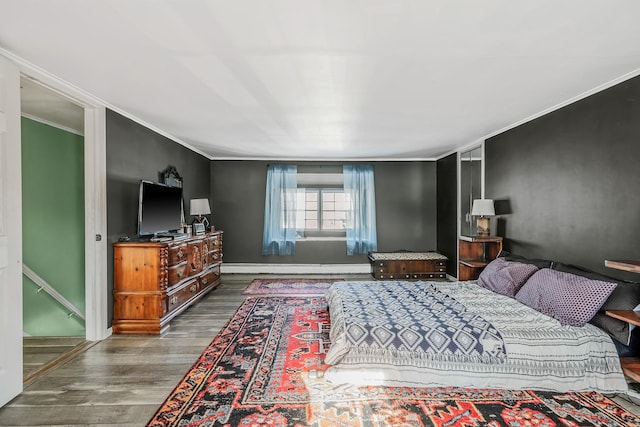 bedroom featuring a baseboard heating unit, ornamental molding, and dark wood-type flooring