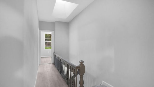 hall featuring light hardwood / wood-style floors and a skylight