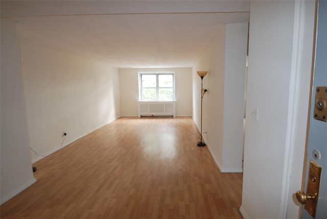 spare room featuring radiator and light wood-type flooring