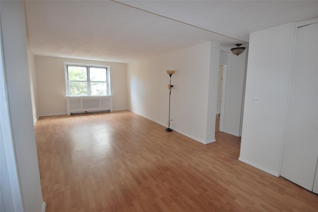 unfurnished room featuring light hardwood / wood-style flooring and radiator heating unit