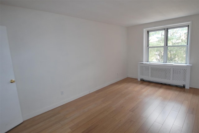 empty room with radiator and light hardwood / wood-style flooring