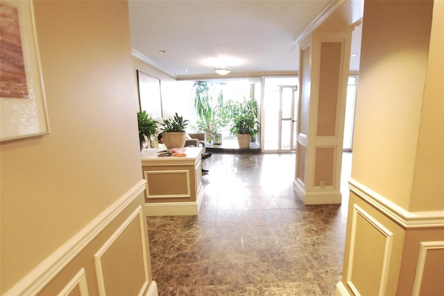 corridor with expansive windows, ornamental molding, and ornate columns