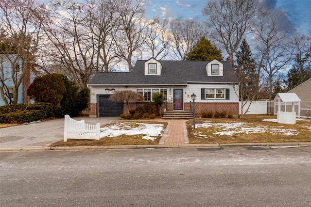 cape cod-style house featuring a garage