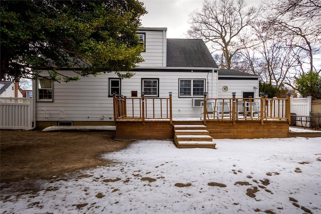 snow covered house featuring a wooden deck