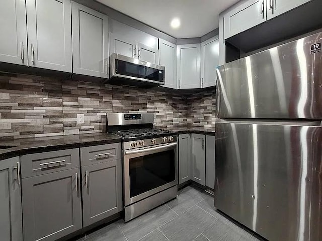 kitchen featuring tasteful backsplash, stainless steel appliances, and gray cabinets