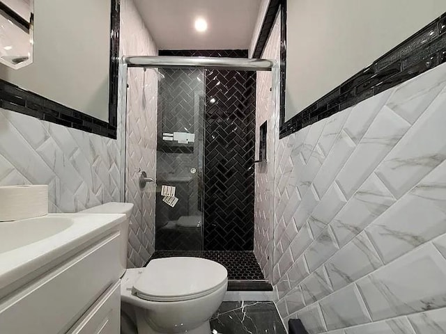 bathroom featuring vanity, tile walls, walk in shower, and toilet