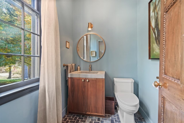 bathroom with vanity, a wealth of natural light, and toilet