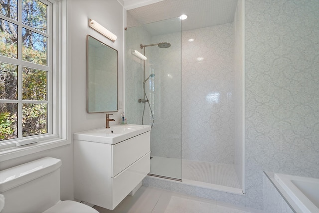 bathroom featuring vanity, tile patterned flooring, toilet, and tiled shower