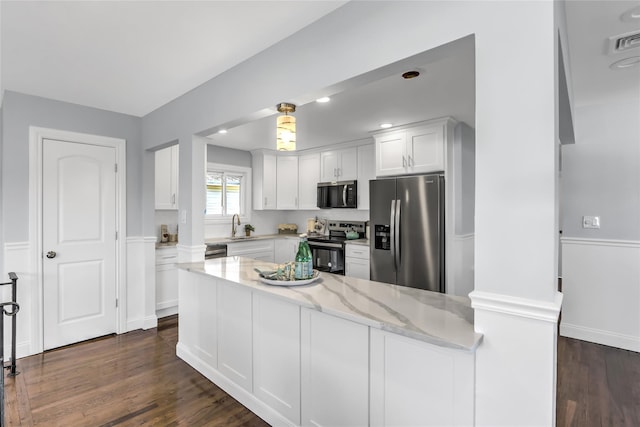 kitchen with sink, white cabinetry, dark hardwood / wood-style floors, stainless steel appliances, and light stone countertops