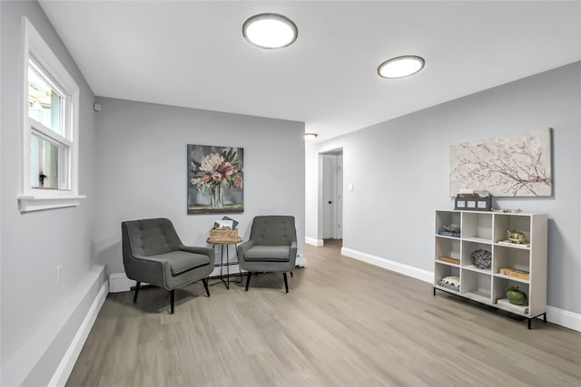 sitting room with light wood-type flooring and baseboard heating