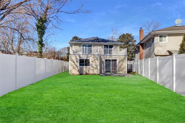 back of property with a balcony and a lawn