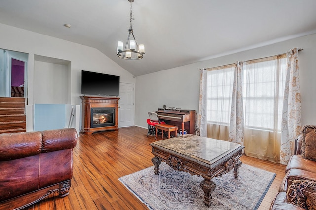 living room featuring lofted ceiling, hardwood / wood-style floors, and a chandelier