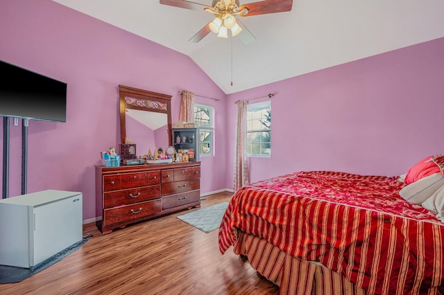 bedroom featuring white refrigerator, ceiling fan, vaulted ceiling, and light hardwood / wood-style flooring