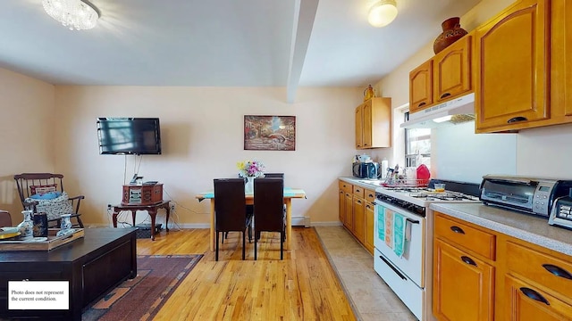 kitchen featuring white gas stove and light wood-type flooring