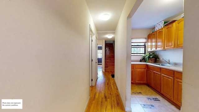 corridor featuring sink and light hardwood / wood-style floors