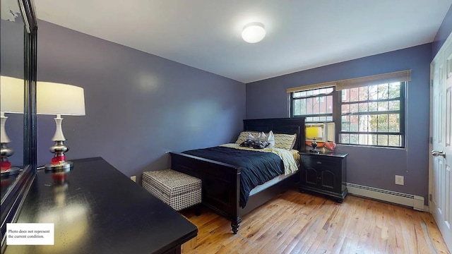 bedroom featuring a baseboard heating unit and light wood-type flooring