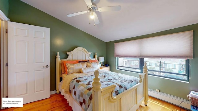 bedroom with a baseboard radiator, vaulted ceiling, ceiling fan, and light wood-type flooring