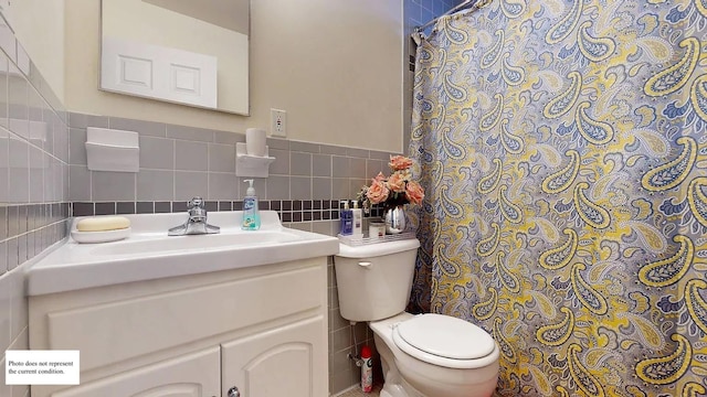 bathroom featuring vanity, tile walls, and toilet