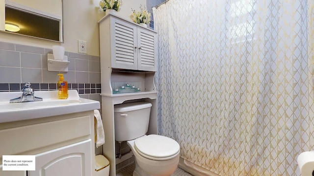 bathroom with a shower with curtain, vanity, toilet, and tile walls