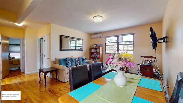 dining area featuring a wall mounted air conditioner, baseboards, and wood finished floors