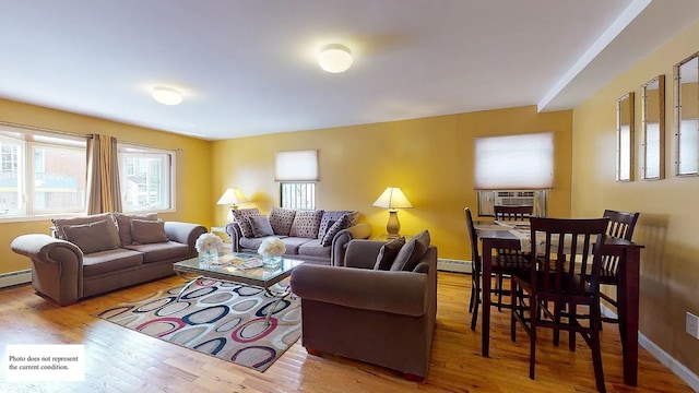 living area with a baseboard heating unit, cooling unit, wood finished floors, and baseboards