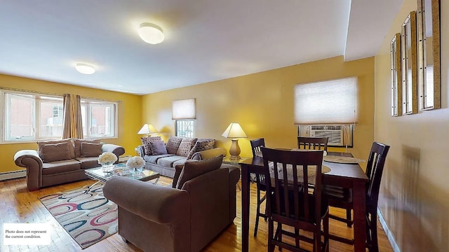 living area with a baseboard heating unit, cooling unit, and wood finished floors