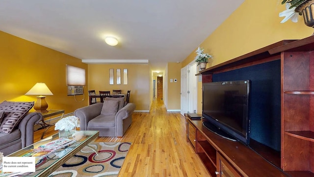 living area with a baseboard radiator, baseboards, light wood-style floors, and cooling unit