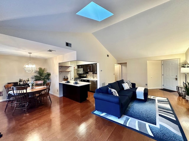 living room featuring a skylight, dark hardwood / wood-style flooring, a chandelier, and high vaulted ceiling