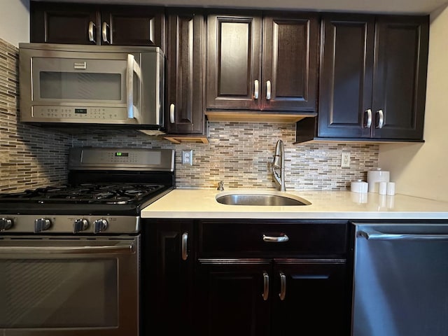 kitchen featuring dark brown cabinetry, sink, backsplash, and appliances with stainless steel finishes