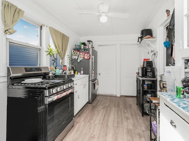 kitchen with white cabinetry, stainless steel appliances, and ceiling fan