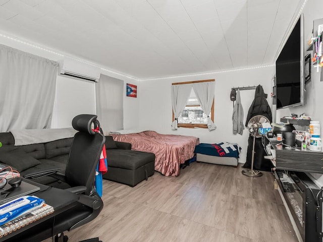 bedroom featuring a wall mounted AC and light hardwood / wood-style floors