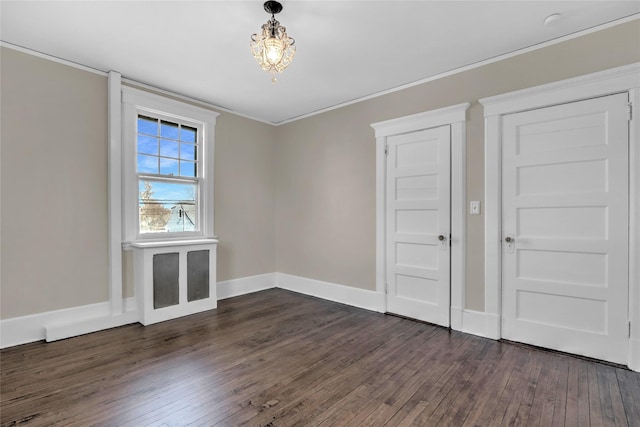 spare room with dark hardwood / wood-style flooring and ornamental molding