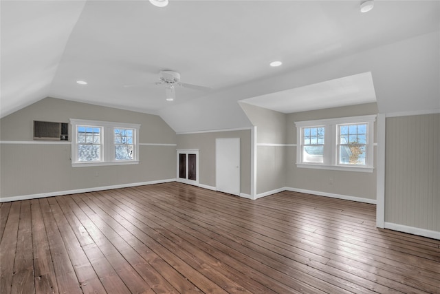 bonus room with dark wood-type flooring, a healthy amount of sunlight, and vaulted ceiling