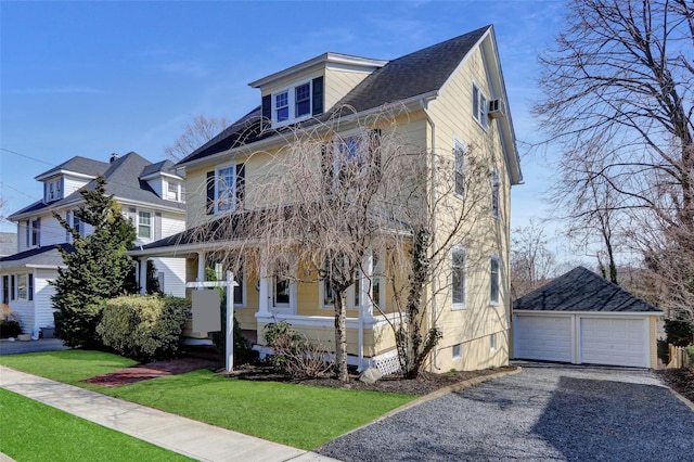 traditional style home with a detached garage, an outdoor structure, and a front lawn