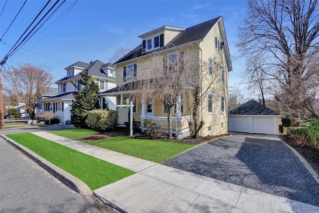 american foursquare style home with a garage, a front lawn, and an outdoor structure