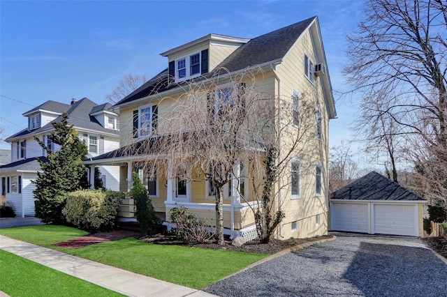 american foursquare style home with an outbuilding, a front yard, and a garage