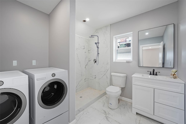 bathroom with vanity, tiled shower, independent washer and dryer, and toilet