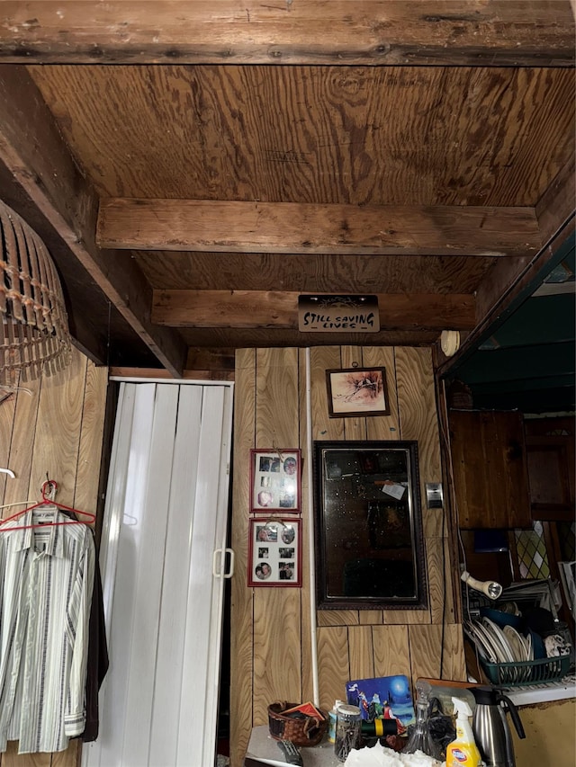 interior space featuring beam ceiling, wood ceiling, and wood walls