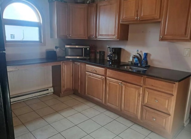 kitchen featuring sink, light tile patterned floors, and baseboard heating