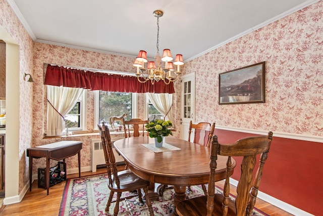 dining room featuring radiator, crown molding, hardwood / wood-style floors, and a chandelier