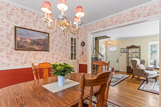 dining room featuring hardwood / wood-style flooring, crown molding, and an inviting chandelier